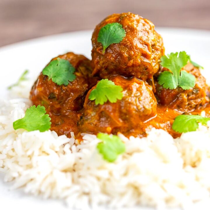 Square image of spicy venison meatballs served with basmati rice and coriander leaves