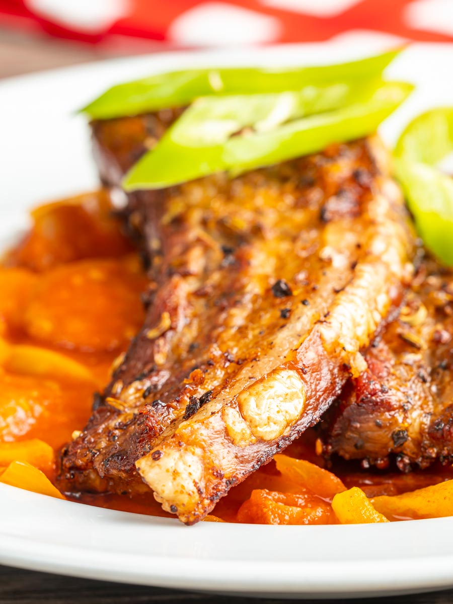Portrait close up image of pork belly slices served on a Hungarian lecso served in a white bowl