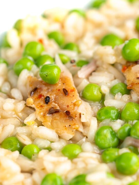 Portrait close up image of a smoked fish risotto with peas