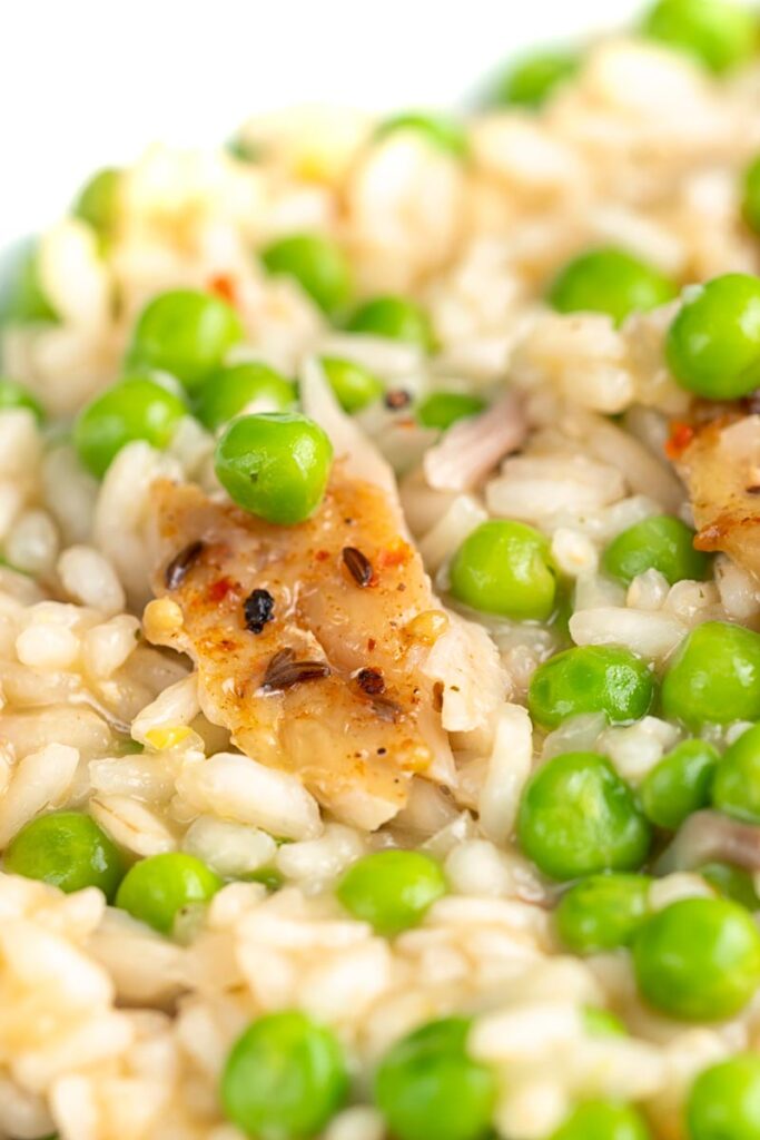 Portrait close up image of a smoked fish risotto with peas