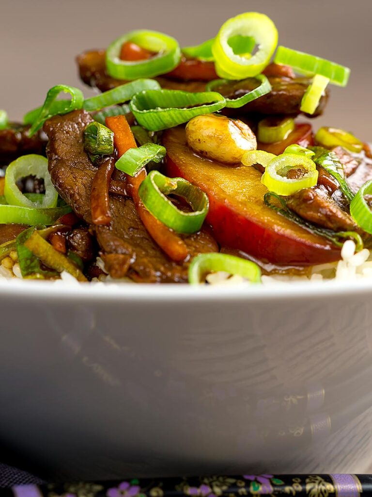 Portrait image of Chinese duck with plums served in a white bowl