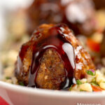 Portrait close up image of Moroccan influenced meatballs with a pomegranate molasses glaze served on a tabbouleh salad with text overlay
