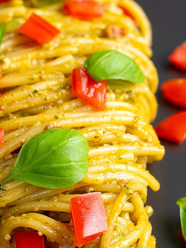 Portrait close up image of pesto alla trapanese served with spaghetti and tomato concasse and fresh basil