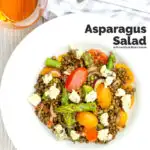 Square overhead image of an asparagus salad with lentils, blue cheese and tomatoes served in a white bowl with text overlay