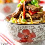 Portrait image of a beef stir fry with noodles, chilli and spring onions served in a bowl decorated in an Asian style with text overlay