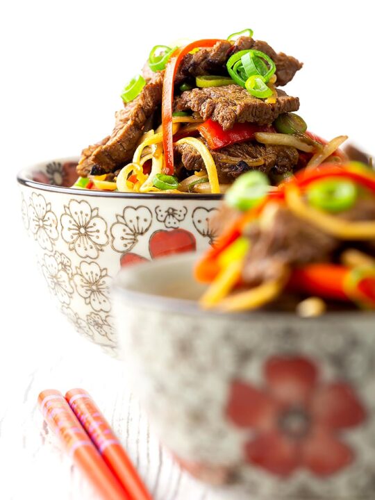 Portrait image of a beef stir fry with noodles, chilli and spring onions