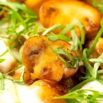 Portrait close up image of baked gnocchi with mushrooms in balsamic vinegar, mozzarella cheese and fresh basil