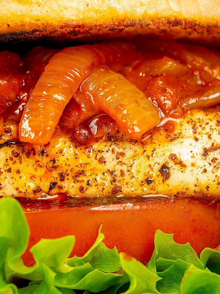 Portrait close up of a halloumi burger with lettuce tomato and onions cooked in harissa