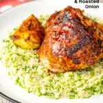 Portrait image of roasted harissa chicken thighs with onion wedges served on herbed couscous