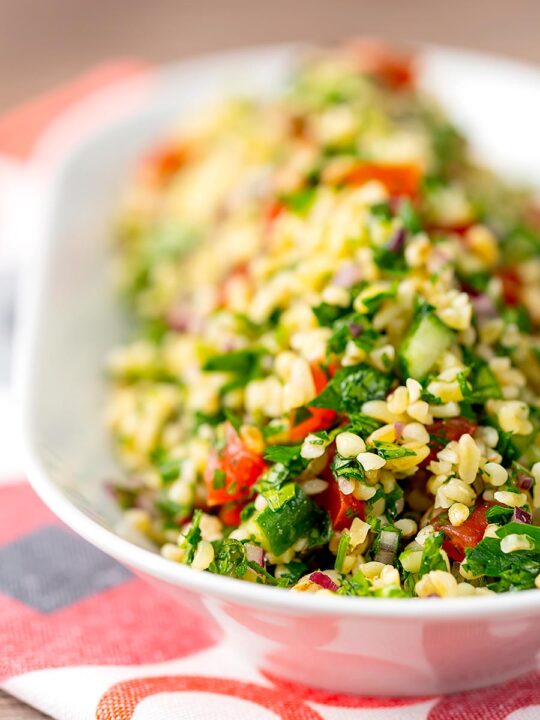 Portrait shallow depth of field image of a herby tabbouleh salad served in a white bowl