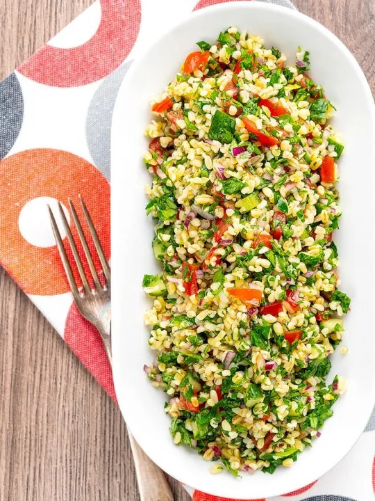 Portrait over head image of a herby tabbouleh salad served in a white bowl