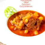Portrait image of a Traditional Hungarian beef goulash or gulyasleves with handmade csipetke (pasta) with text overlay