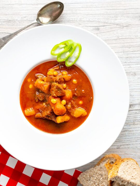 Portrait overhead image of a Traditional Hungarian beef goulash or gulyasleves with handmade csipetke (pasta)
