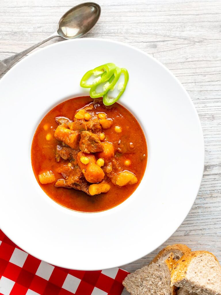 Portrait overhead image of a Traditional Hungarian beef goulash or gulyasleves with handmade csipetke (pasta)