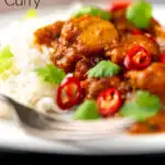 Portrait close up image of a chicken pathia or patia curry served on a plate with rice, chilli slices and fresh coriander with text overlay