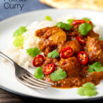 Portrait image of a chicken pathia or patia curry served on a plate with rice, chilli slices and fresh coriander with text overlay