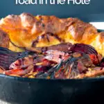 Portrait close up image of a roasted vegetable toad in the hole cooked and served in a cast iron pan with text overlay