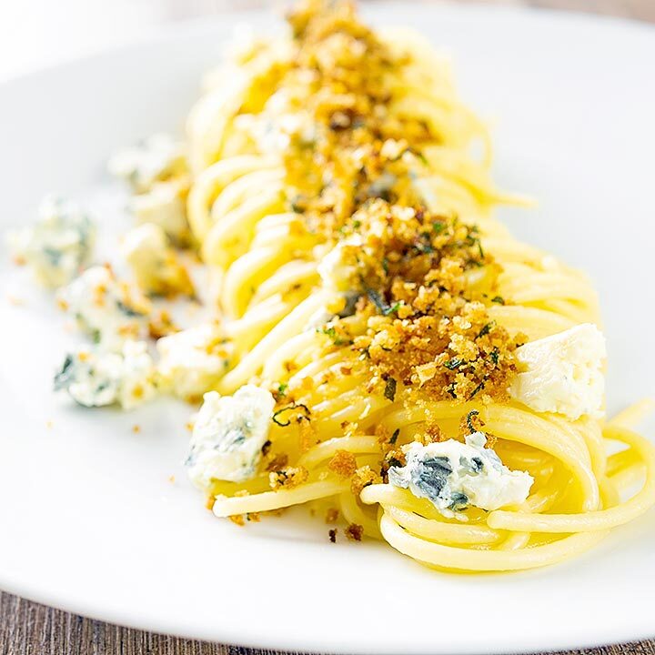 Square image of a blue cheese pasta recipe featuring spaghetti coated in garlic butter, a buttery sage crumb and Gorgonzola cheese