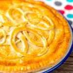 Portrait image of a cheese and onion plate pie with a text overlay