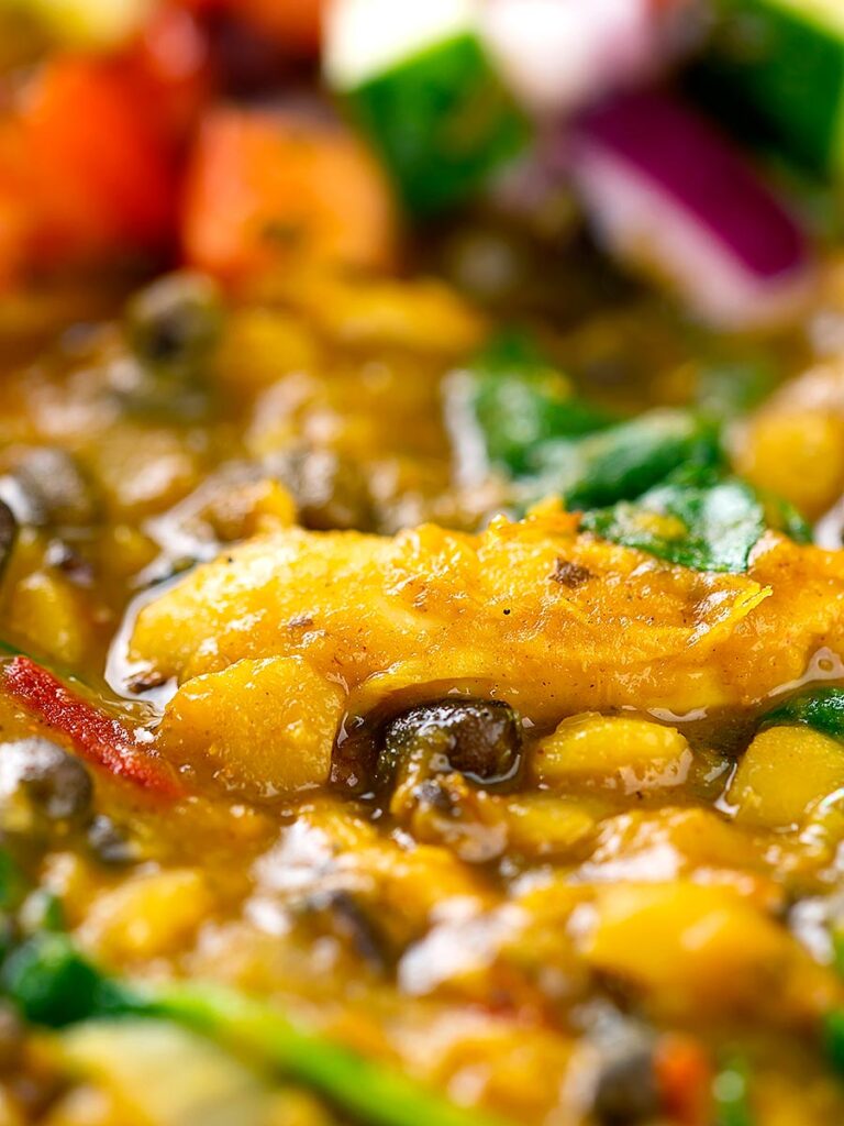 Portrait close up image of an Indian Chicken Dhansak lentil curry served with a kachumber salad