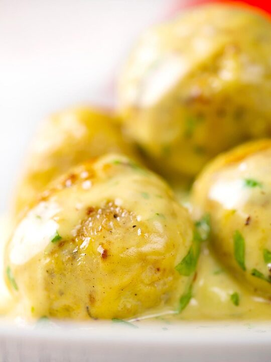 Portrait close up image of chicken meatballs in a creamy honey and mustard sauce