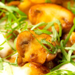 Portrait close up image of baked gnocchi with mushrooms in balsamic vinegar, mozzarella cheese and fresh basil with a text overlay