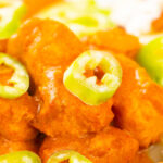 Portrait close up image of a Hungarian fish paprikash or harcsapaprikas served on a white plate in a silky paprika rich sauce with a text overlay