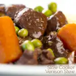 Portrait close up image of a slow cooker venison stew or casserole served with peas & carrots with a text overlay
