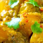 Portrait close up image of a Burmese influenced vegan pumpkin curry served with white rice and fresh coriander