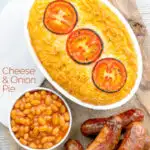 Portrait overhead image of cheese and potato pie bake topped with tomato slices and served with sausages and baked beans featuring a text overlay