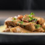 Portrait close up image of a Hungarian Pork Stew called Borsos Tokany served steaming hot with fresh parsley