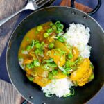 Portrait overhead image of a takeaway influenced Chinese chicken curry with garden peas and spring onions