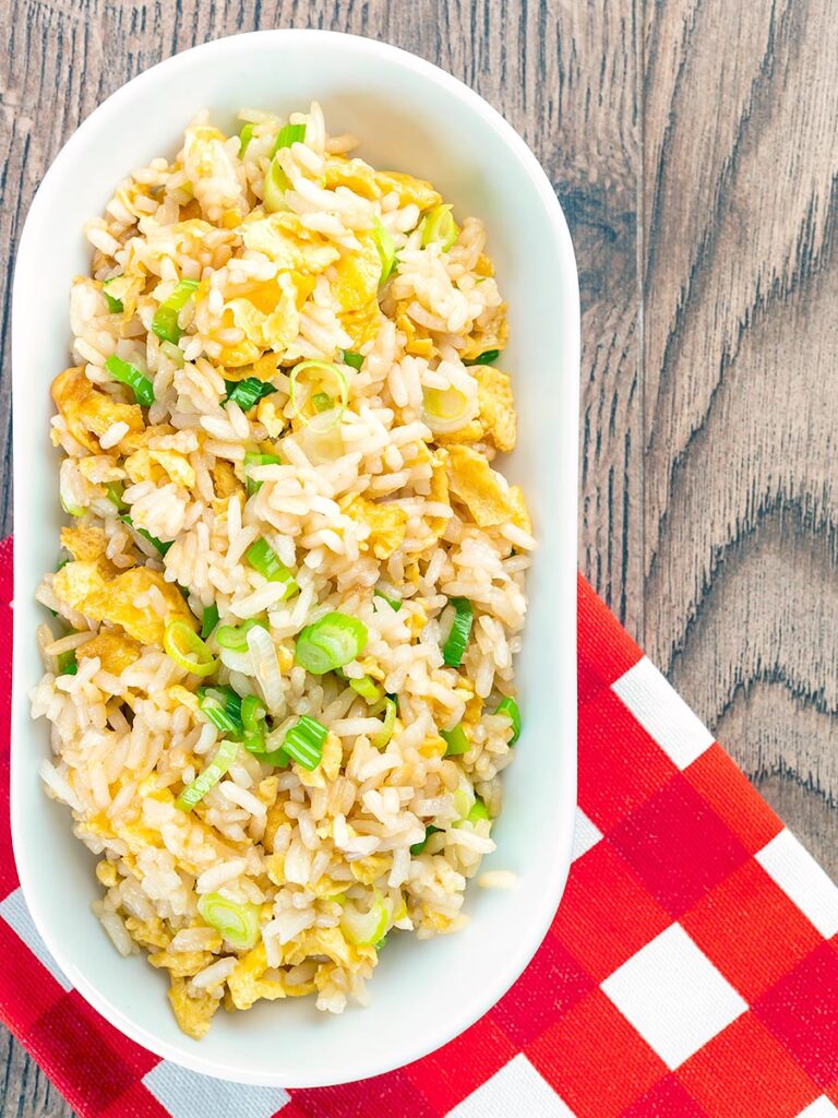 Portrait overhead image of egg fried rice served in a white bowl