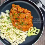 Portrait overhead image of a Hungarian inspired pork paprikash or sertéspaprikás served with nokedli on a grey plate featuring a title overlay