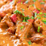 Portrait close up image of a Hungarian inspired pork paprikash or sertéspaprikás served with nokedli on a grey plate featuring a title overlay
