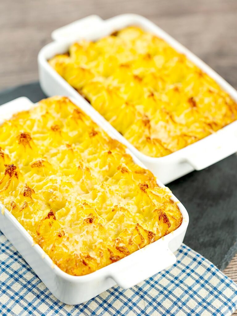 Portrait image of individual vegetarian shepherds pies or shepherdess pies served in white gratin dishes