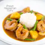 Portrait image of a Thai Prawn Massaman Curry with potatoes and green beans served in a white bowl featuring a text overlay