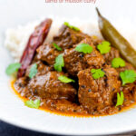 Portrait image of an achar gosht curry served on a white plate with whole chilies, basmati rice featuring a text overlay