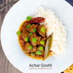 Portrait overhead image of an achar gosht curry served on a white plate with whole chilies, basmati rice and a naan bread featuring a text overlay