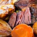 Portrait close up image of beer braised beef cheeks with carrot, shallot and mushrooms