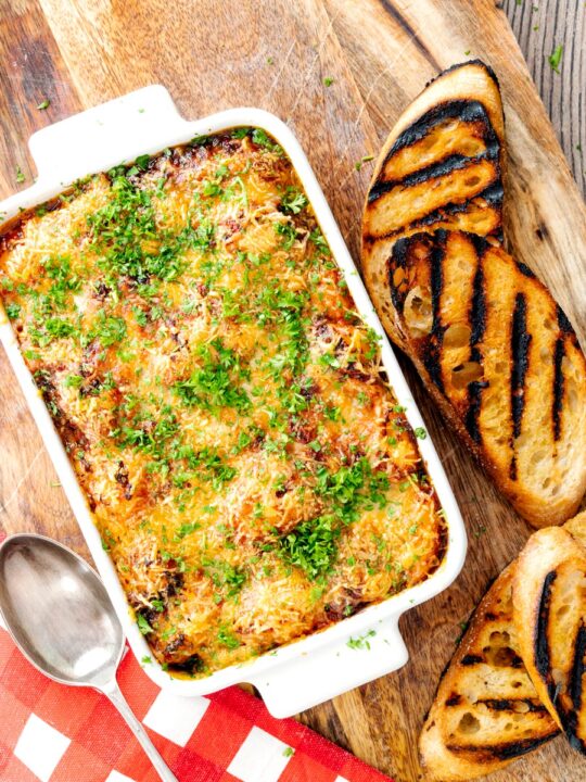 Portrait overhead image of gnocchi alla Sorrentina served in a gratin dish with griddled bread