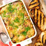 Portrait overhead image of gnocchi alla Sorrentina served in a gratin dish with griddled bread featuring a title overlay