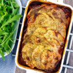 Portrait overhead image if a sliced potato topped spicy beef hotpot served in a gratin bowl
