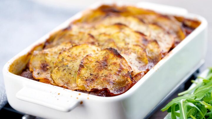 Landscape image if a sliced potato topped spicy beef hotpot served in a gratin bowl
