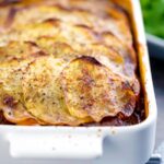 Portrait image if a sliced potato topped spicy beef hotpot served in a gratin bowl