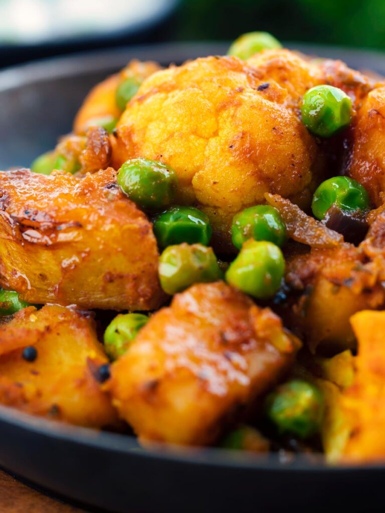 Close up Aloo gobi matar curry served served in an iron karai
