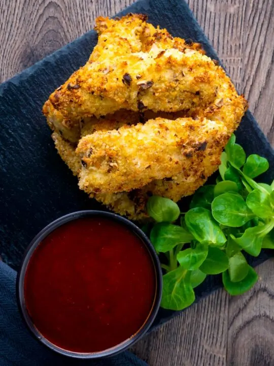 Overhead of chicken goujons in a hazelnut and breadcrumb with a spicy dipping sauce