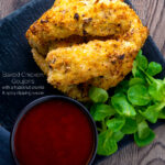 Overhead of chicken goujons in a hazelnut and breadcrumb with a spicy dipping sauce featuring a title overlay