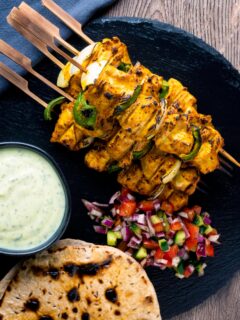 Overhead chicken tikka kebabs served with chapati, kachumber salad & raita