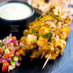 Chicken tikka kebab with onion and green pepper served with kachumber salad & raita featuring a title overlay